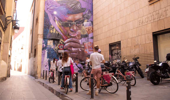 Ciclisti davanti al murale di Keith Haring