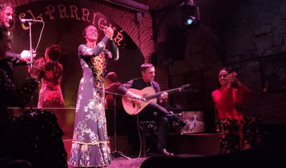 Mujer tocando palmas y músicos