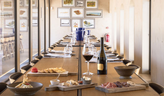 A large table with appetizers and bottles of wine