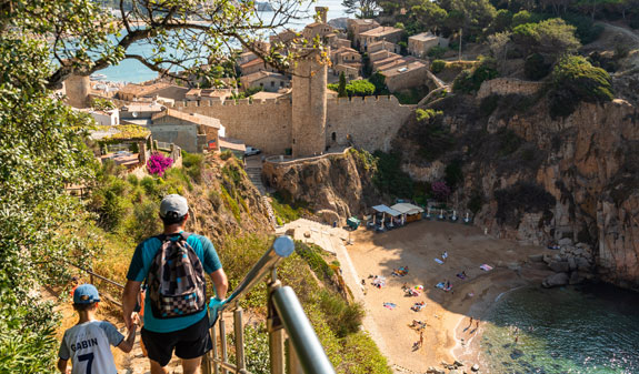 Pare i fill passejant pel camí de ronda de Tossa de Mar
