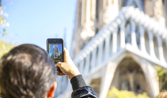 Visitatore che fotografa la facciata della Sagrada Família di Gaudí