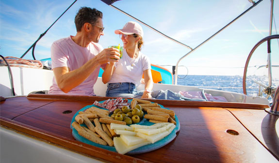 couple having a vermouth on a sailboat