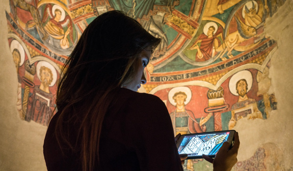 Girl looking a videoguide of a Romanesque work at the National Museum of Art of Catalonia Barcelona
