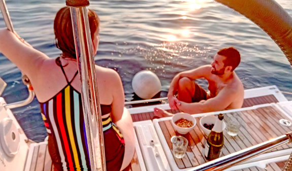 Couple sunbathing on a sailboat in the sea