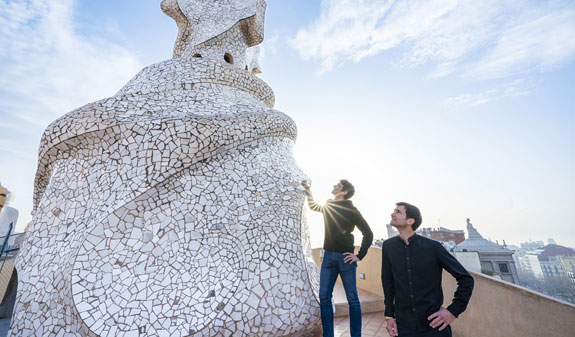 Visitantes al amanecer junto a una chimenea de La Pedrera
